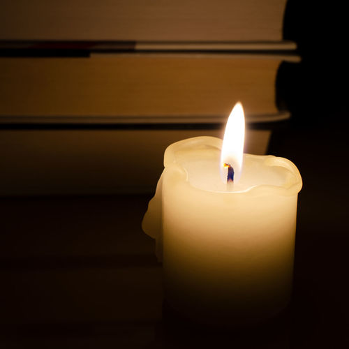 Close-up of lit candle in darkroom