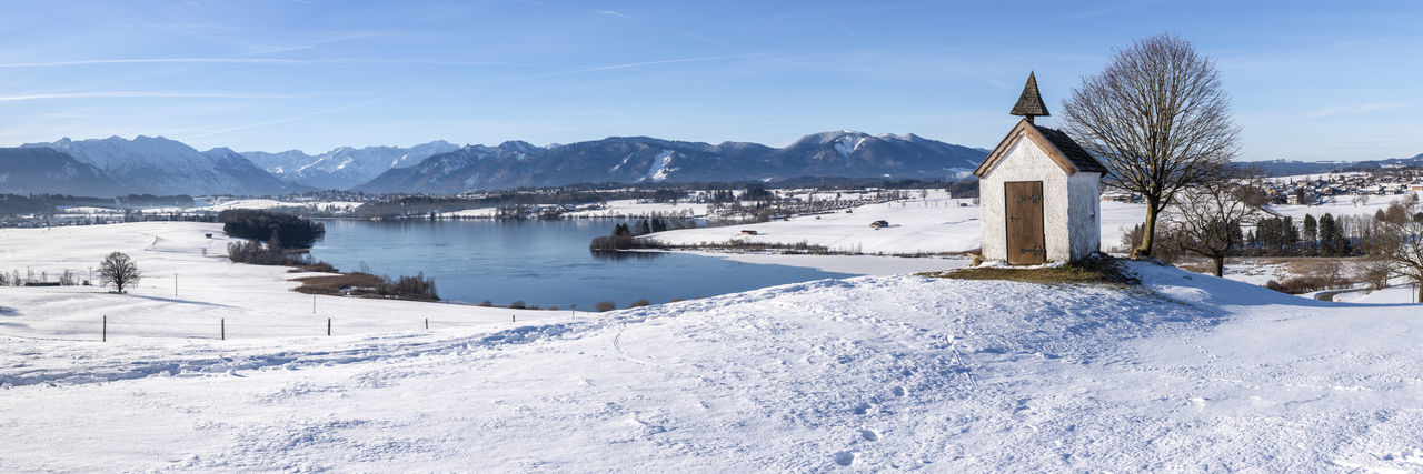 Panoramic view to mountain range behind lake in winter