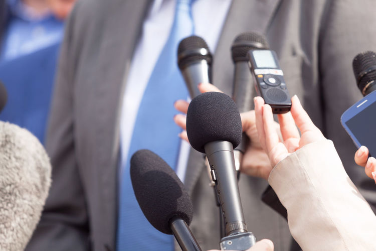 Cropped image of journalists interviewing businessman