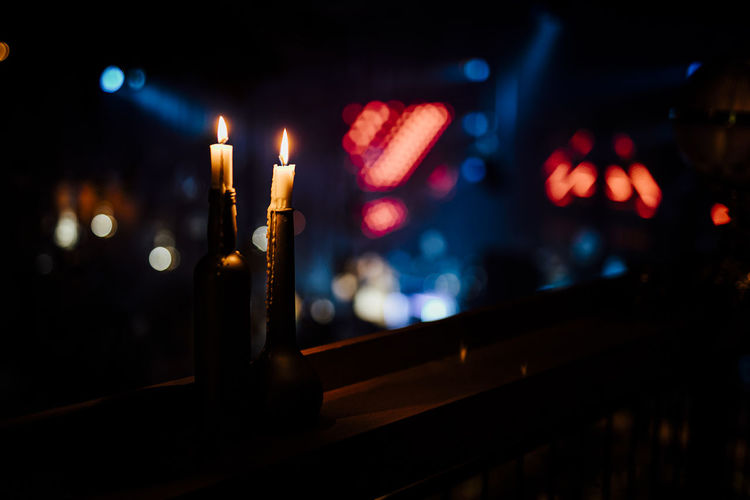 Close-up of candle on window sill at night