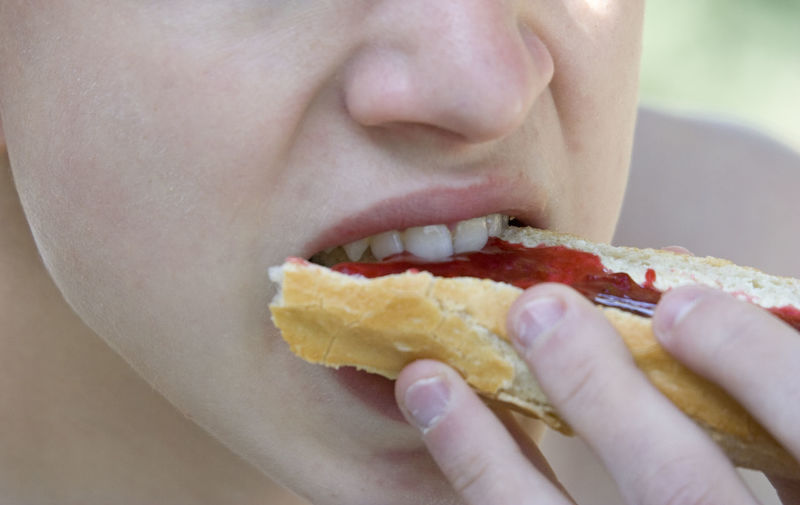 Midsection of woman eating jam bread