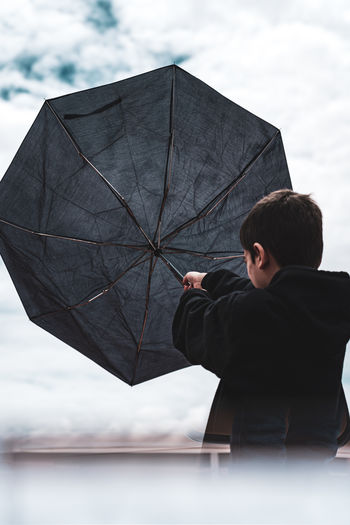 A boy holding an umbrella.