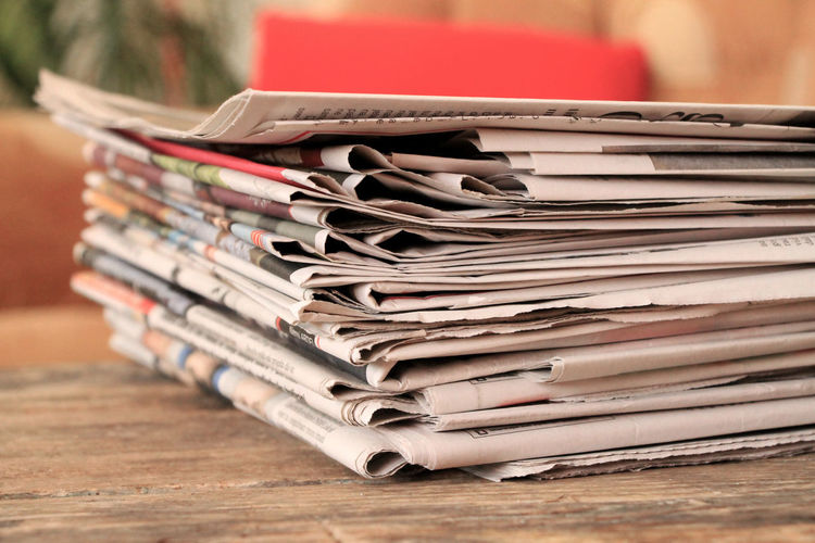 Stack of newspapers on wooden table