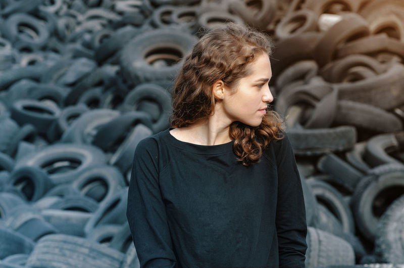 Young woman standing by tires