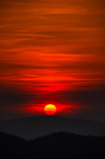 Scenic view of silhouette landscape against orange sky