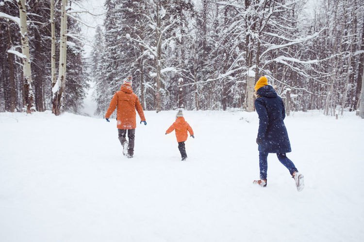 Family have fun winter ourtors, run in snow