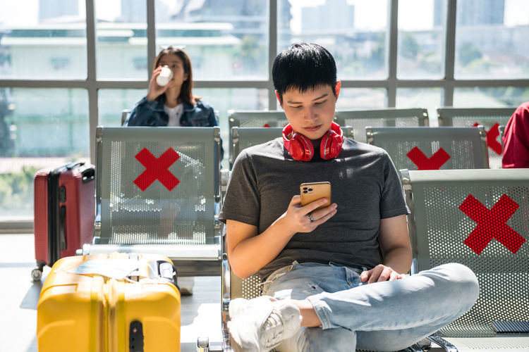 Young woman using mobile phone while sitting on table