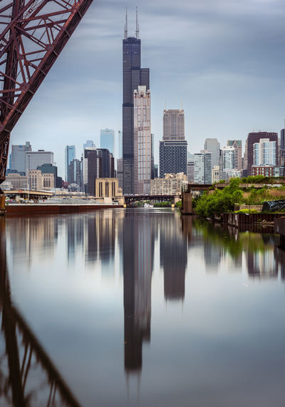 Reflection of buildings in river against sky