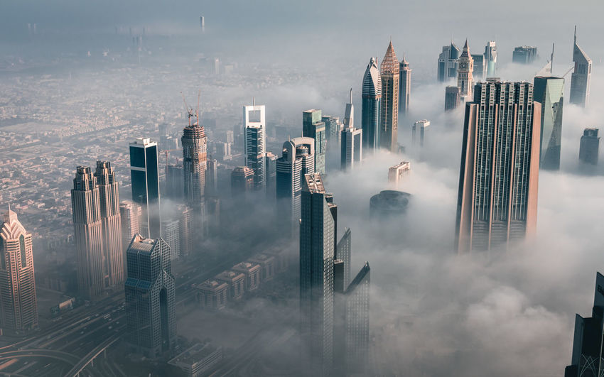 High angle view of skyscrapers in dubai's financial district amongst the early morning fog