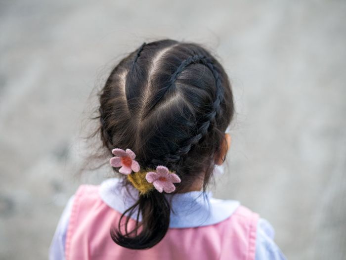 Rear view of girl with pink flowers on head