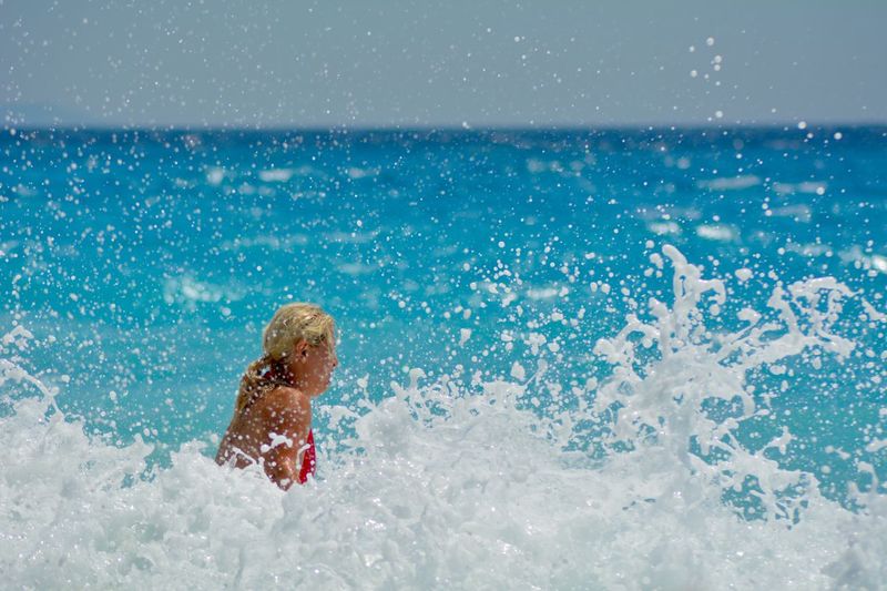 Splashing water against woman swimming in sea