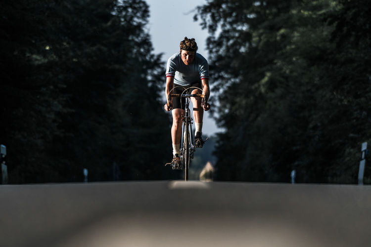 Young man riding bicycle on road
