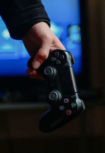 Close-up of hand holding gaming console