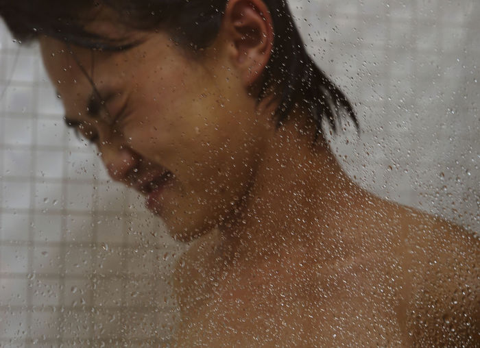 Close-up of young man taking bath
