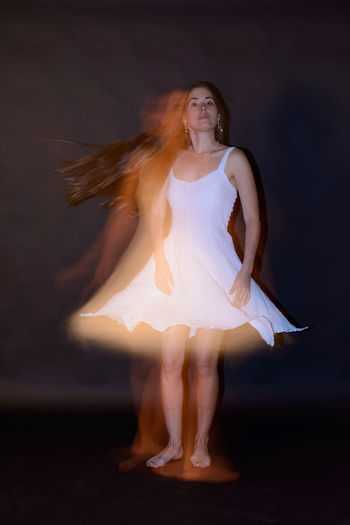 Beautiful young woman dancing at night