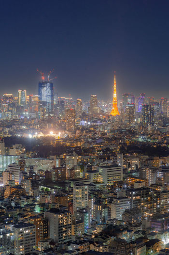 Illuminated cityscape against sky at night