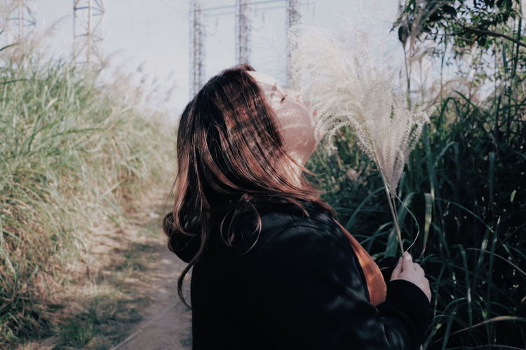 Side view of woman standing amidst plants