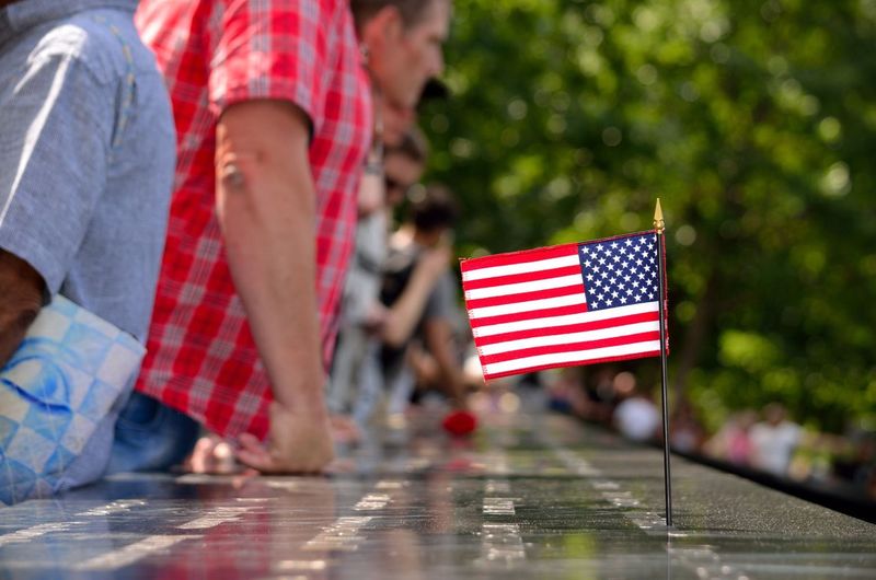 People by american flag at national september 11 memorial and museum