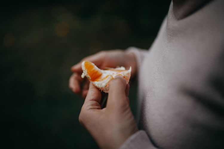 Close-up of hand holding orange