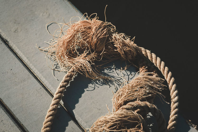 High angle view of old rope on wooden plank