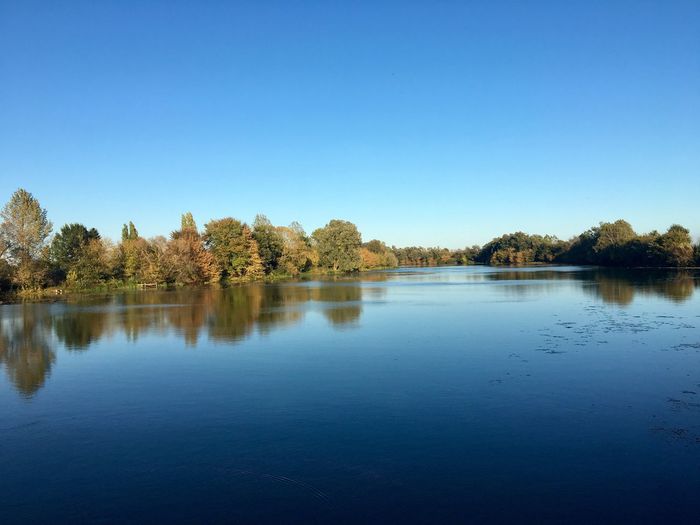 Scenic view of lake against clear blue sky