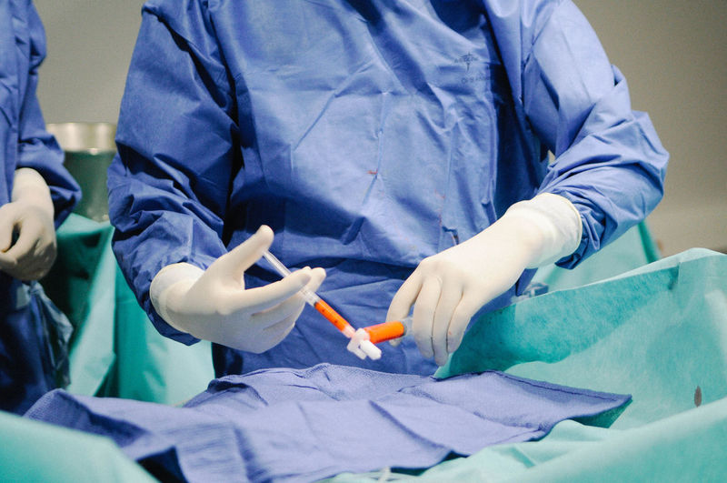 Midsection of surgeons in operating room at hospital