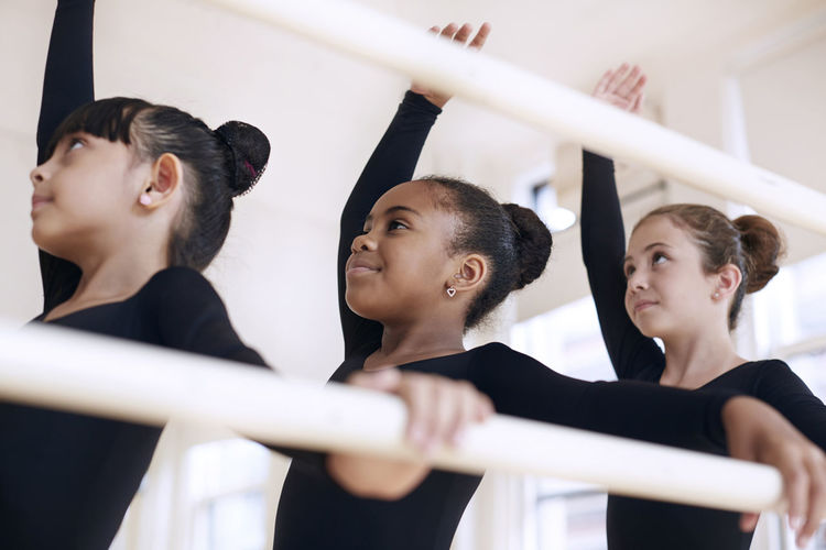 Low angle view of confident ballerinas performing in studio