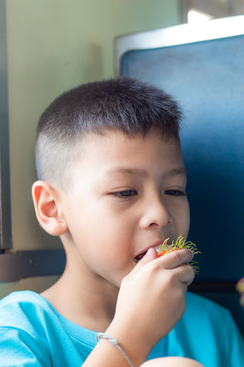 Close-up of cute boy eating in train