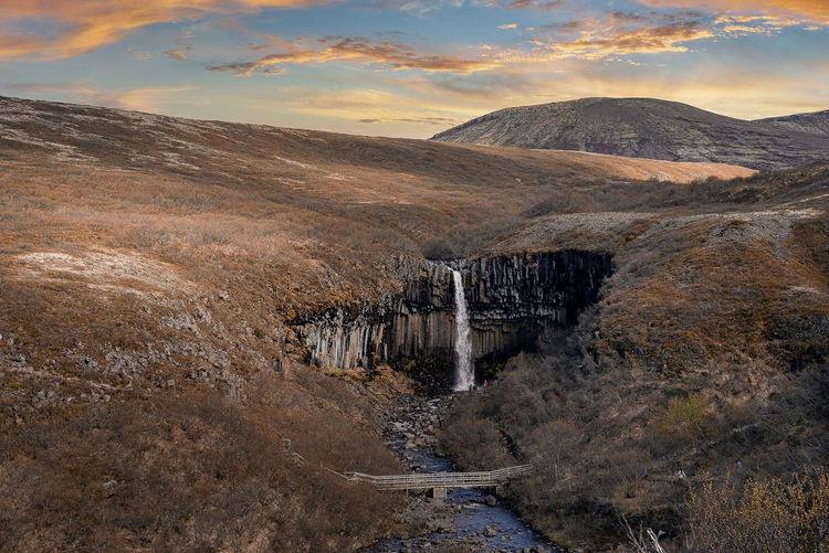 Aerial view of svartifoss waterfall surrounded by basalt columns during sunset