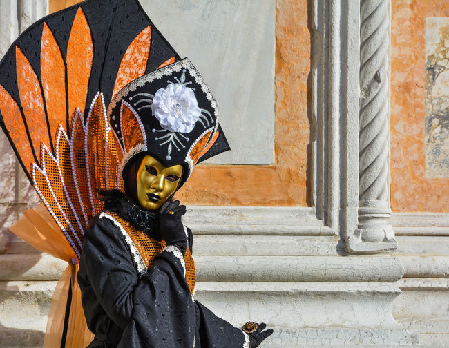 Portrait of person dressed up for carnival against wall