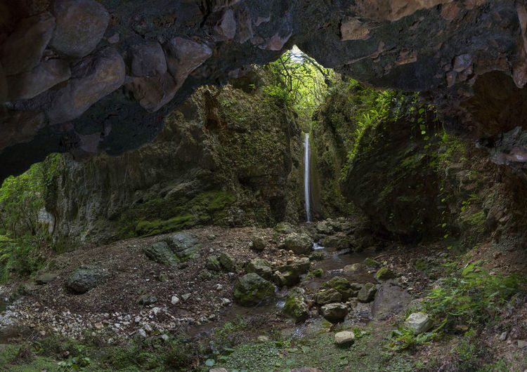 Scenic view of waterfall seen through cave