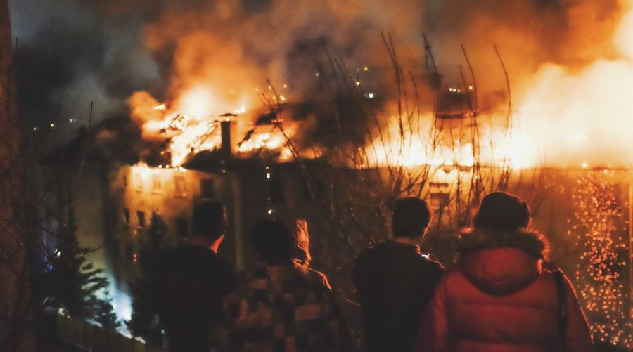 People watching fire on building at night