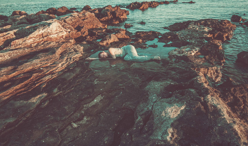 High angle view of woman lying on shore