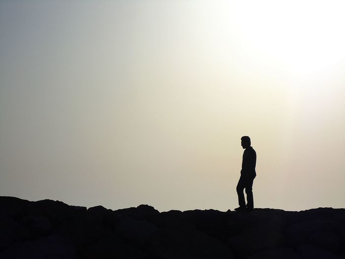 Silhouette of woman standing on rock