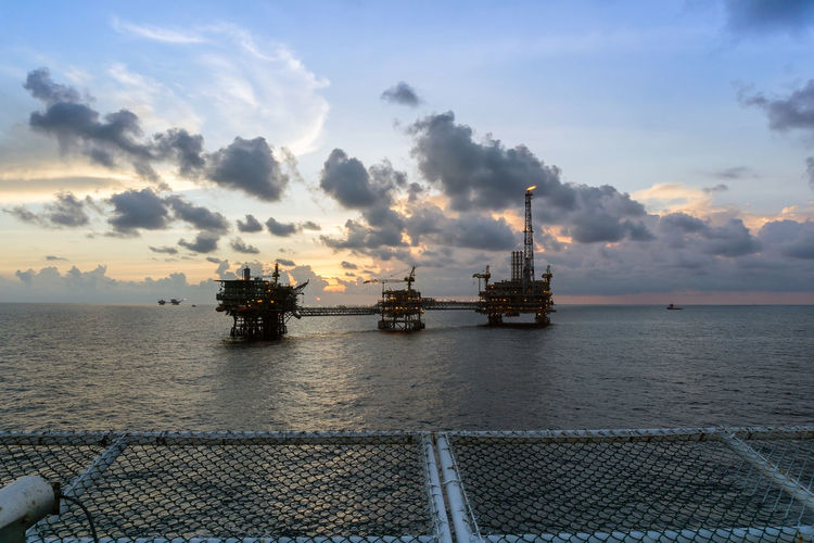 An oil production platform complex viewed from a helipad of a construction work barge at offshore 
