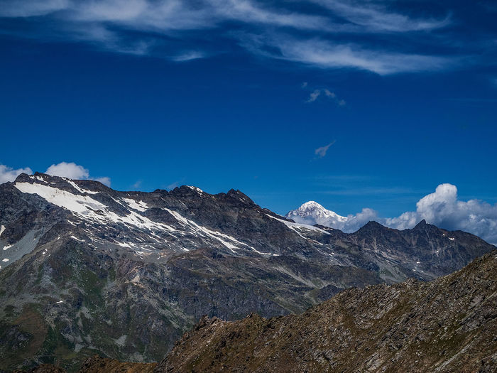 Scenic view of snowcapped mountains against blue sky