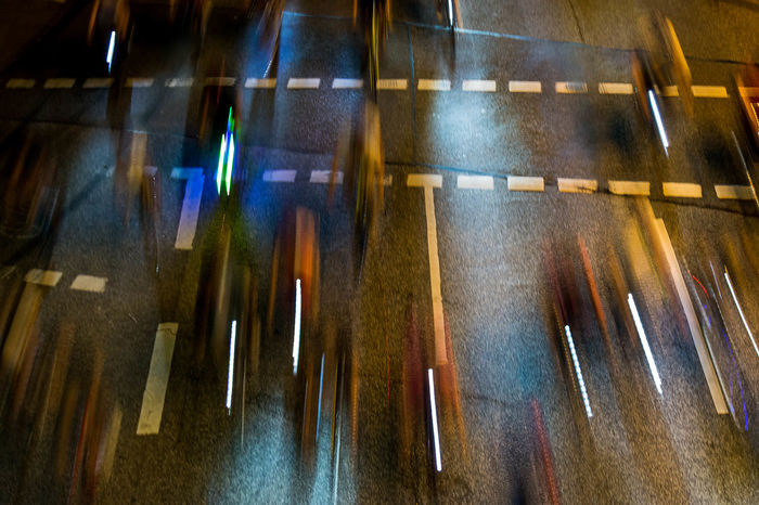 Blurred motion of people riding bicycles on street at night