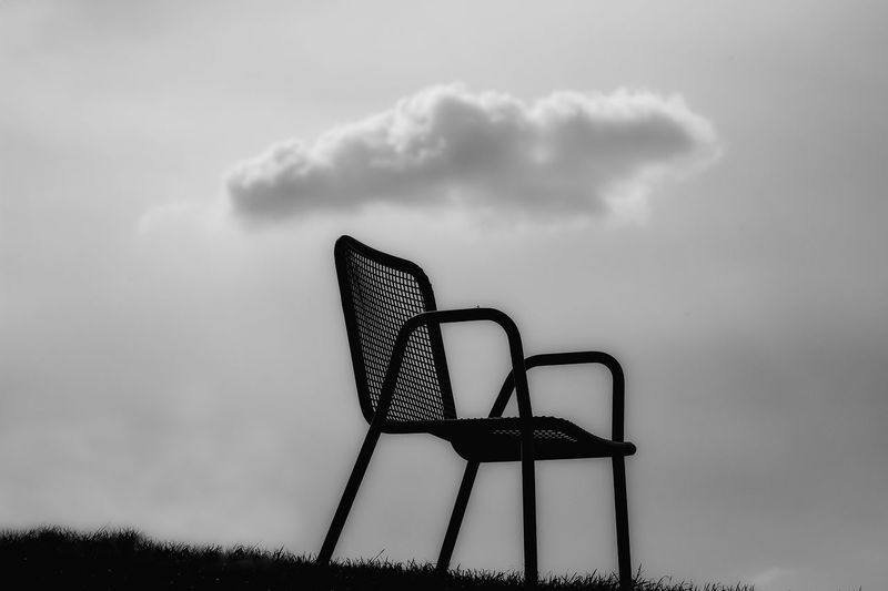 Low angle view of empty chair against sky