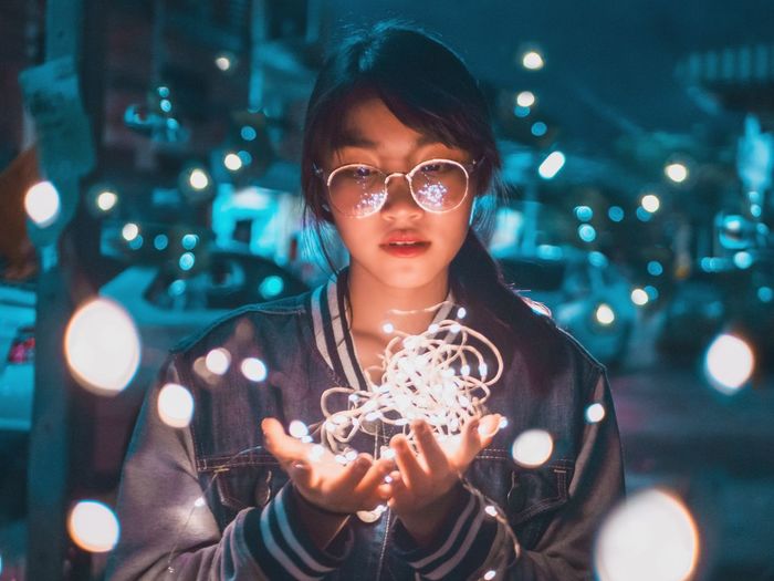 Woman looking at illuminated string light