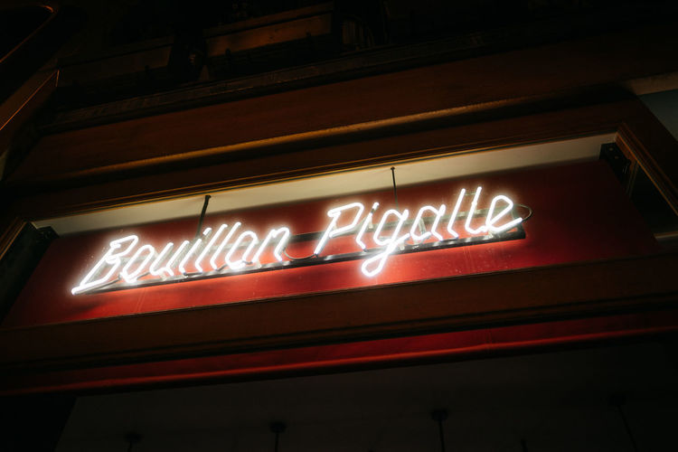 Low angle view of illuminated sign at night