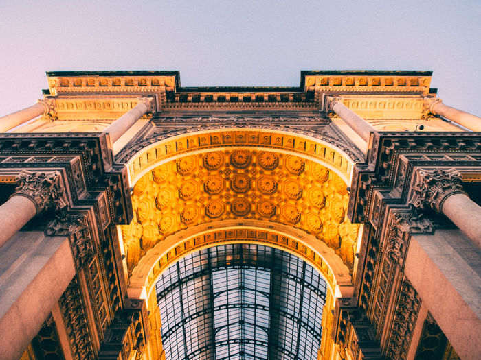 Low angle view of illuminated triumphal arch against clear sky