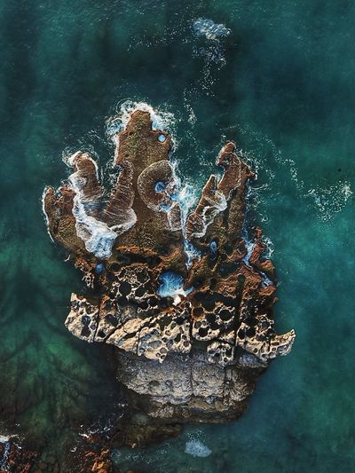 Drone view of rock formation amidst sea