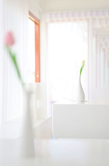Close-up of white vase against wall at home