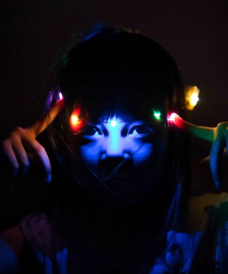 Close-up of woman with face lighting paint