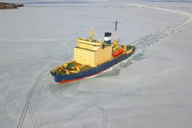 High angle view of frozen boat moored in sea during winter