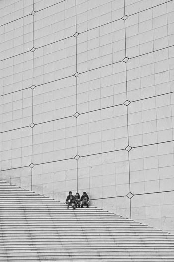 People sitting on staircase against wall