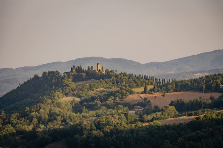 Ruins of an ancient medieval castle at sunset in the tuscan hills