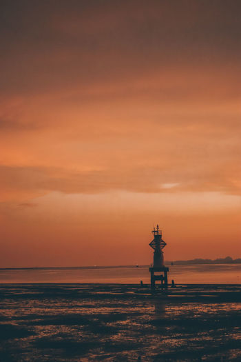Statue of lighthouse at sunset