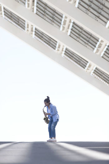 Full length of man using mobile phone against sky