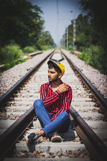 Man sitting on railroad track